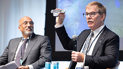 In a panel on Innovating Quantum Sensing, Dana Anderson of Infleqtion displays a component of Infleqtion’s quantum sensor for rotation and acceleration.Photo by Anne Ryan