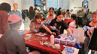 Children swarm to build their own small coin batteries under the guidance of UChicago Pritzker School of Molecular Engineering researchers at the Amanchukwu Lab's yearly Battery Day event, part of the Griffin Museum of Science and Industry's Science Works STEM fair. (Photo by Paul Dailing)